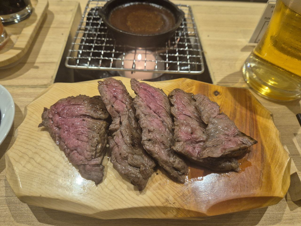 숯불 향이 입혀진 쫄깃한 식감의 치마살 스테이크와 개인용 미니 화로가 세팅된 테이블