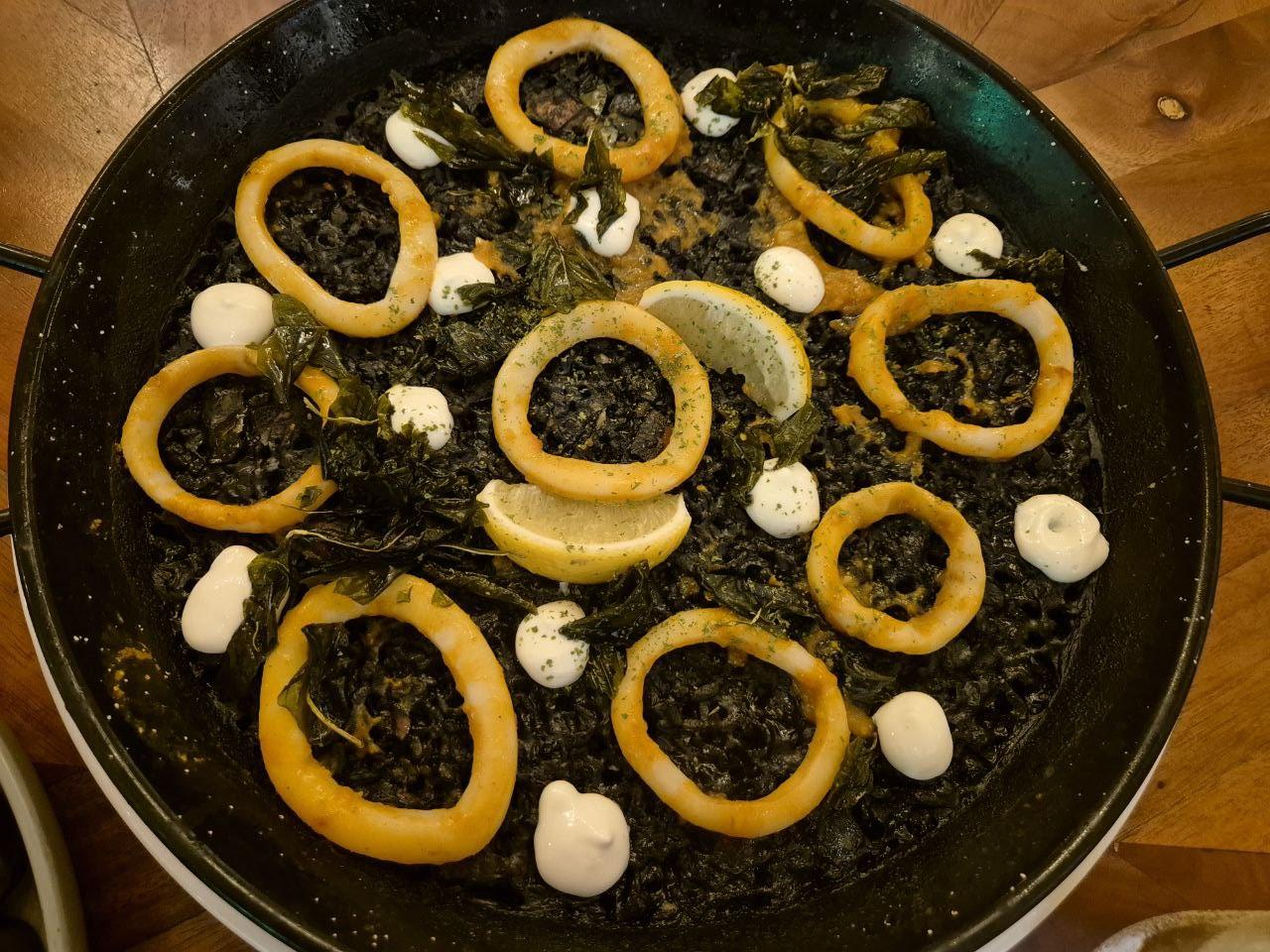 오징어 먹물의 진한 풍미와 아이올리 소스가 어우러진 정통 스페인식 파에야 네그라