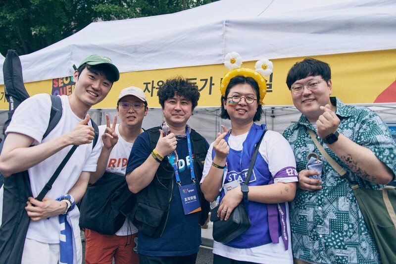 지난해 6월14일 서울퀴어문화축제 현장에서 환하게 웃으며 손가락 하트와 포즈를 취하고 있는 ‘남성과 함께하는 페미니즘’ 활동가들과 필자(맨 왼쪽). 필자 제공