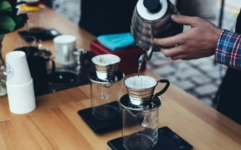 A barista uses paper filters to brew coffee.