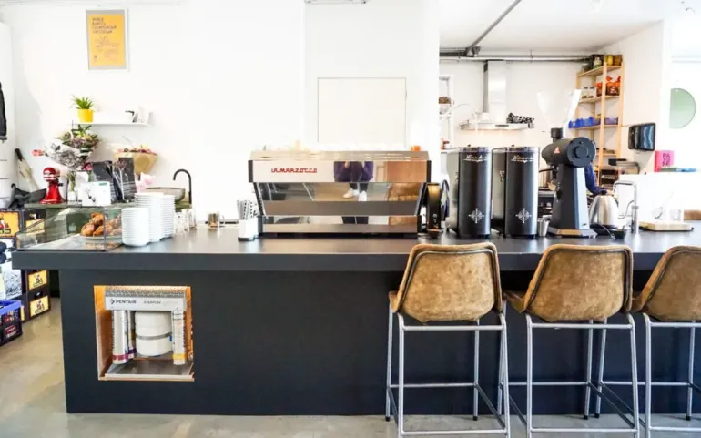 The front bar of a coffee shop featuring an espresso machine.