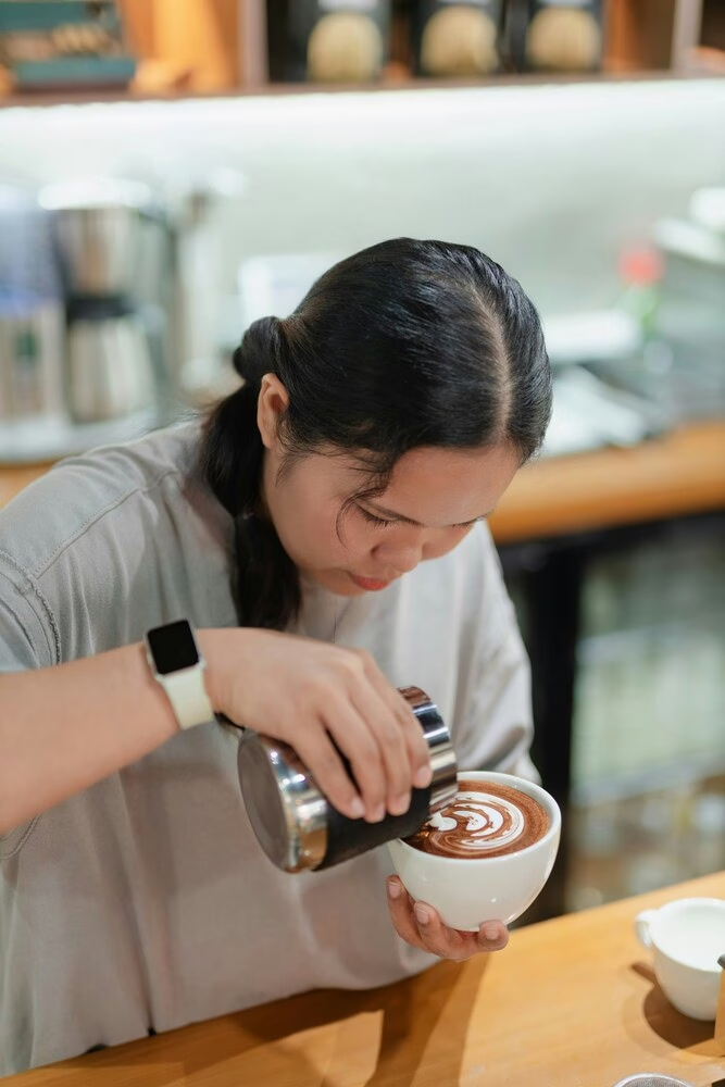 식물성 우유: 카페에서 바리스타가 라떼 아트를 하고 있다.