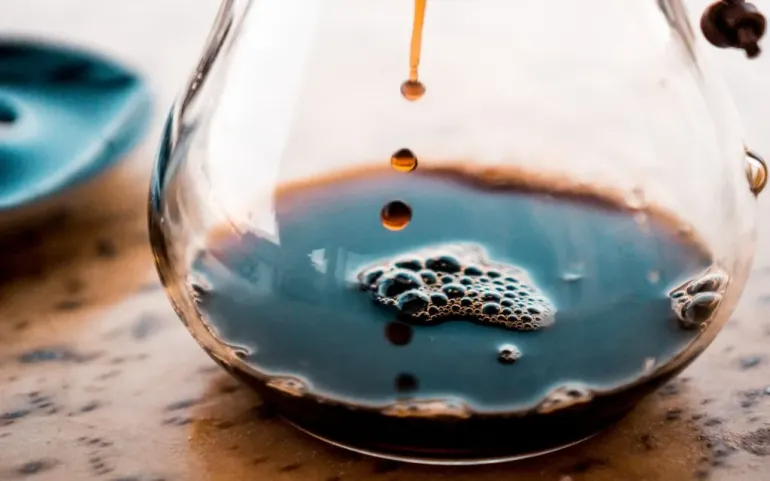 Filter coffee drips into a carafe.