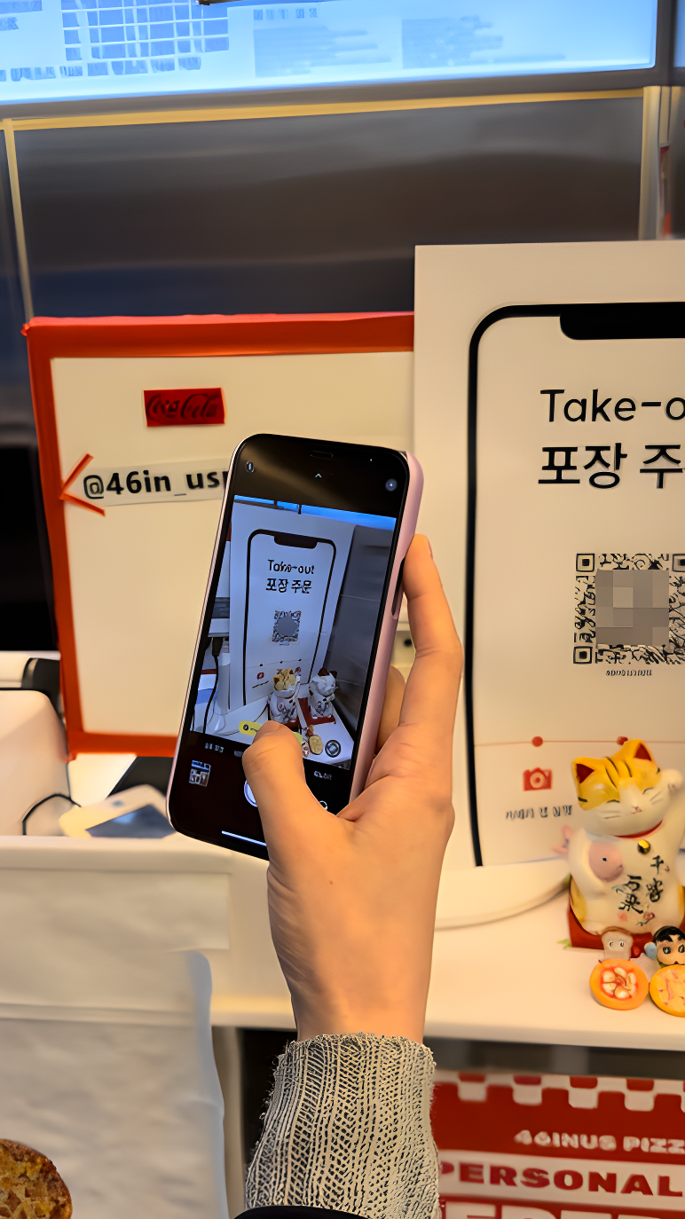 매장 입구에서 포장 전용 메이트 QR 포스터를 스마트폰으로 스캔하는 손님