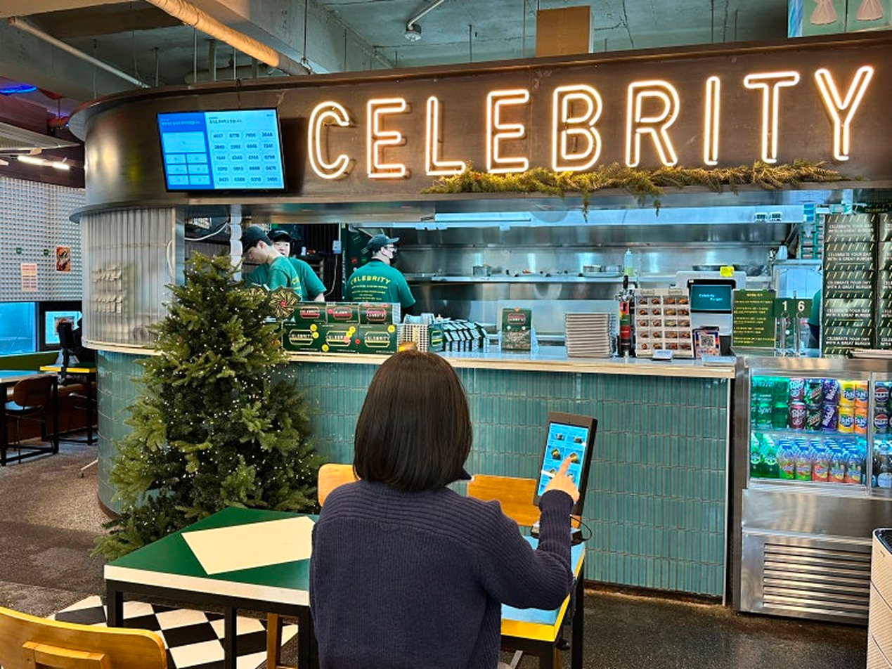 자리에서 편안하게 DID 모니터를 확인하고 대기하는 셀러브리티 버거 매장